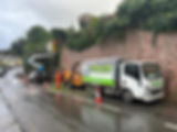 Tree that is being removed and hedge trimmed from the side of a wall on a public road