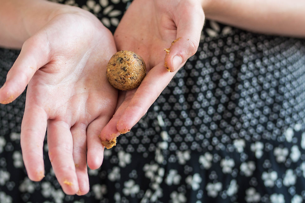 Hands holding a just-rolled energy bite snack