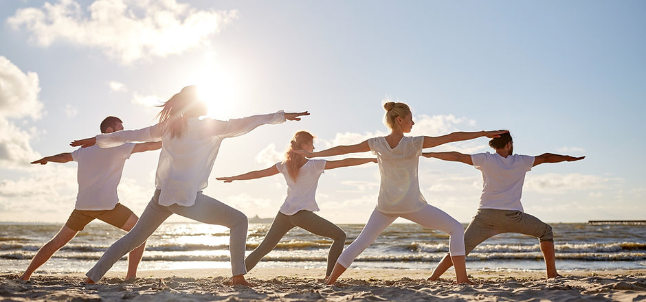 Small yoga group on a beach