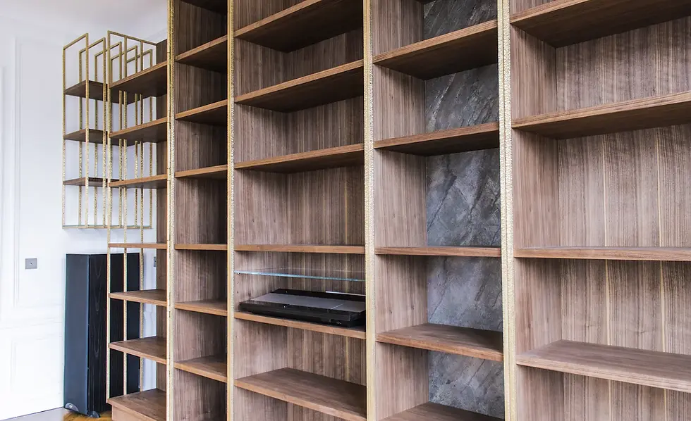 Perspective latérale de la bibliothèque sculpturale en noyer et laiton, mettant en valeur ses lignes épurées et son intégration dans l’espace.