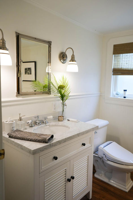 white bathroom with white cabinet and marble sink 