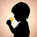 A child's profile silhouette holding a single bright puzzle piece, representing missing wo