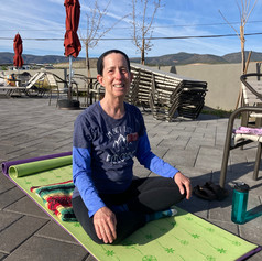 Yoga student sitting on yoga mat.