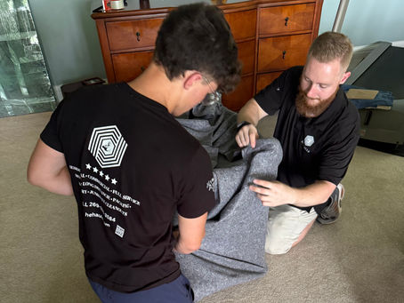 Professional movers from HE-HAULS wrapping furniture into a moving truck in Southwest Michigan