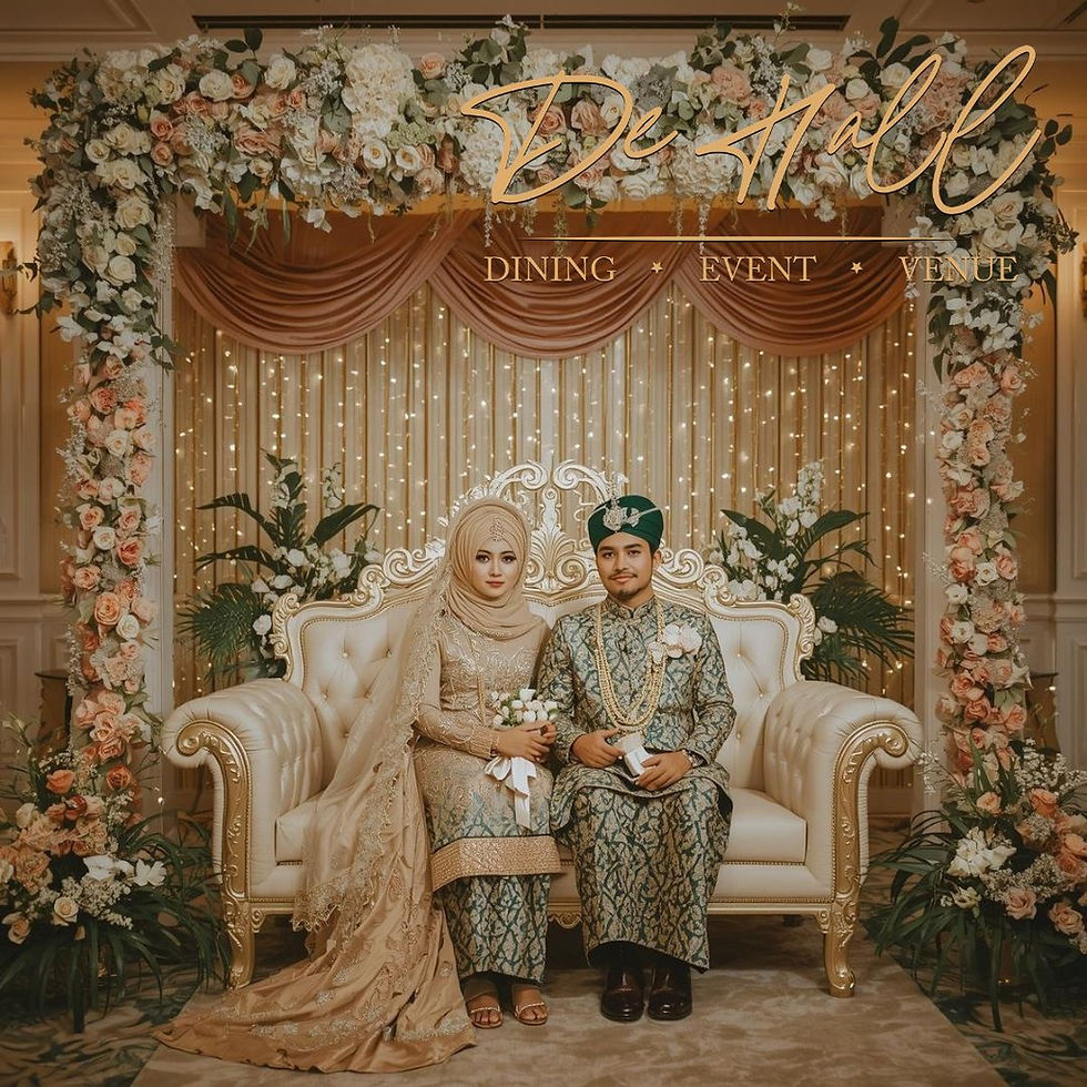 A couple in traditional attire sits on an ornate sofa in a floral-decorated venue. "De Hall" sign above; mood is elegant and serene.