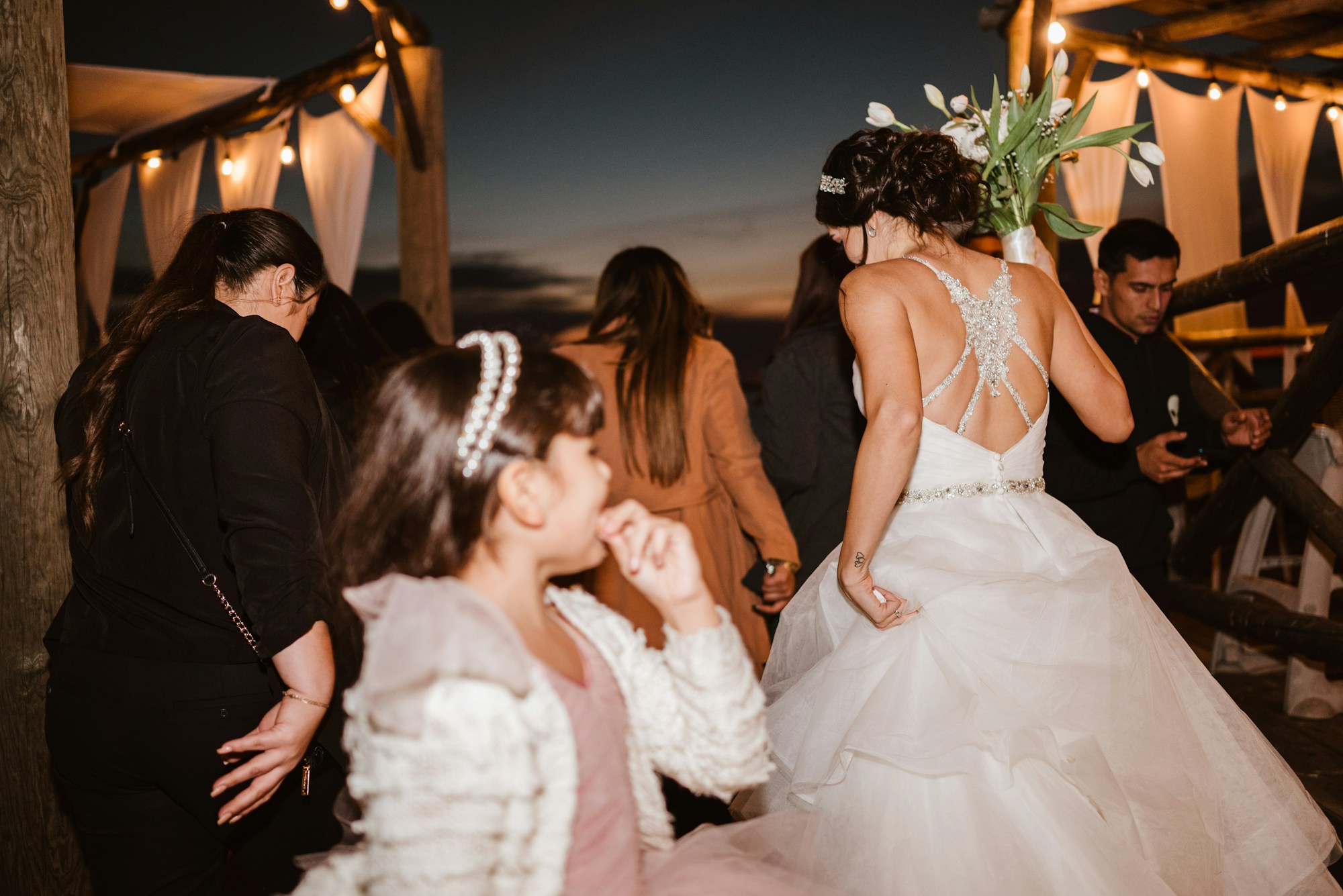 Bride celebrating and dancing with guests at an outdoor wedding reception