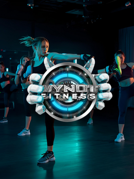 The WYNOT FITNESS futuristic teal, black, grey, and white circular logo held by two white ai hands. Over an image of WYNOT Fitness Transformers taking a WYNOT KB, cardio kickboxing class.
