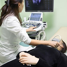 Technician performing thyroid ultrasound on patient