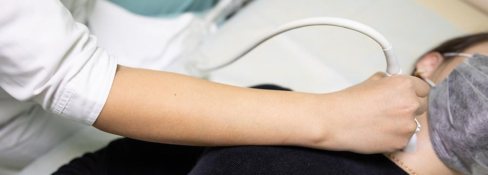 Medical professional performing ultrasound on patient's neck.