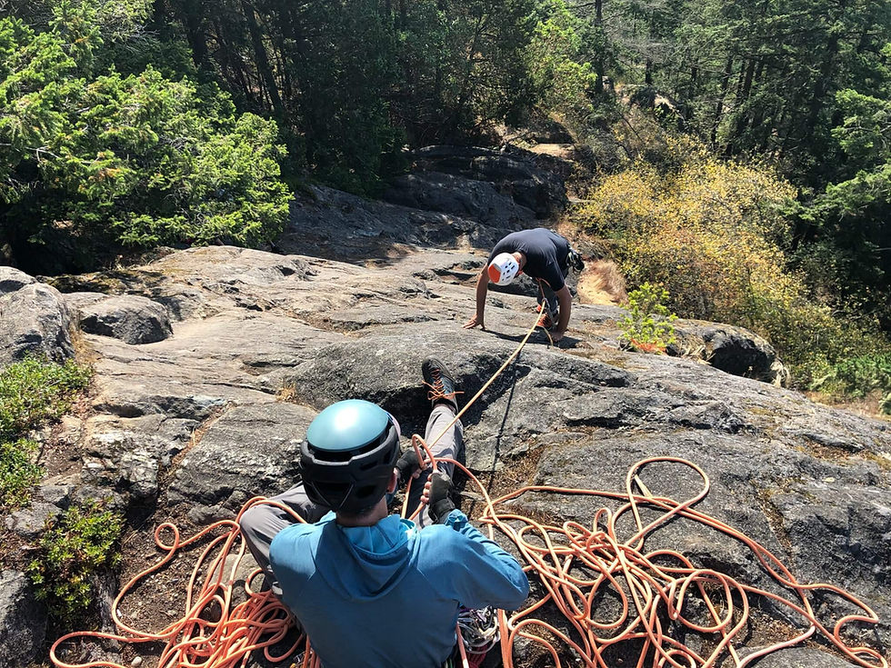 A climber belaying their partner off their rock climbing harness