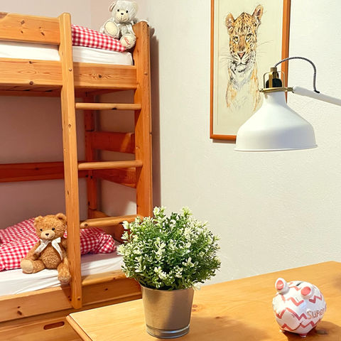 Kinderzimmer mit einem Doppelstockbett, gut gesicherter Leiter und einem Holzschrank.