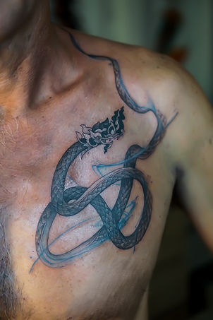 Best Blackwork Thai Naga tattoo with flow by Baan Khagee Tattoo Chiang Mai, Thailand