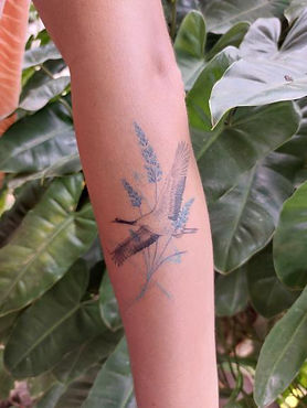 Healed Japanese crane with lavender flowrs tattoo on the forearm by Baan Khagee Tattoo Chiang Mai, Thailand