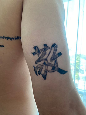 Healed Chinese character with wolf inside tattoo on the upper arm by Baan Khagee Tattoo Chiang Mai, Thailand