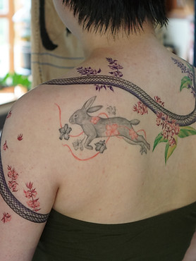 Healed rabbit with flowers tattoo on the back by Baan Khagee Tattoo Chiang Mai, Thailand