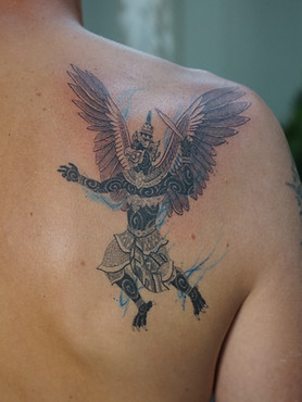 Healed blackwork Thai Garuda tattoo on the back shoulder by Baan Khagee Tattoo Chiang Mai, Thailand