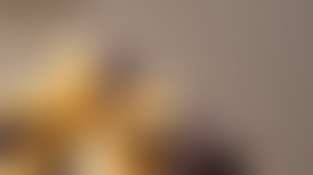 Photographie aux tons bruns montrant un petit cadeau emballé, posé dans une ambiance chaleureuse et douce, évoquant l’esprit de décembre et les attentions symboliques offertes au cabinet.