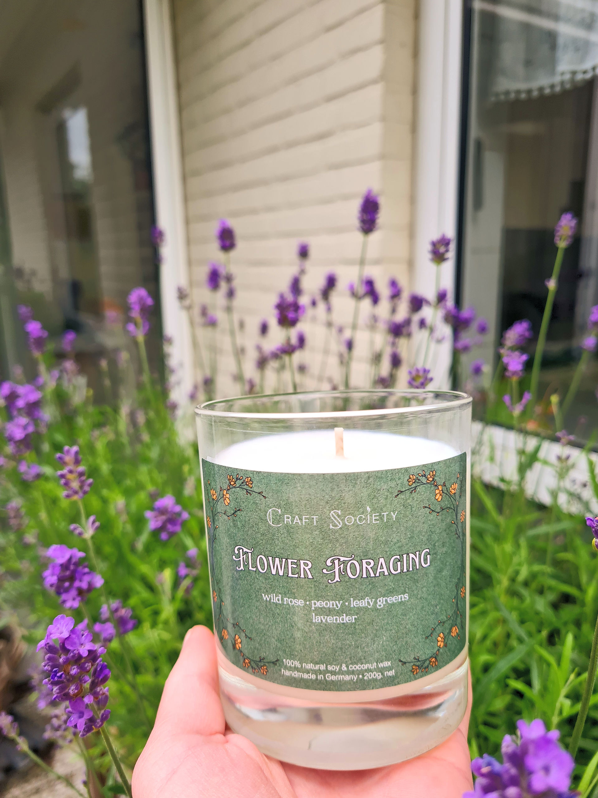 a candle infront of lavender plants