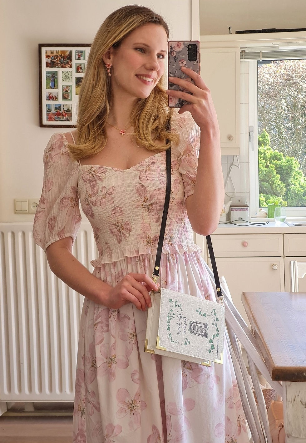 a woman wearing a cottagecore flower print dress and holding a bag