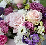 Pink, purple and white florals arranged in a Mother's Day gift basket.