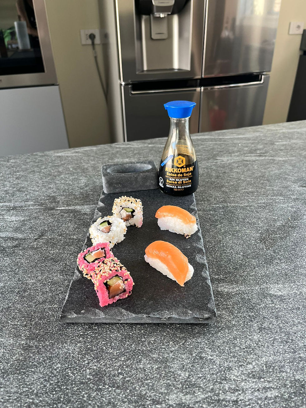 piatto di marmo nero assoluto con porzione di sushi e salsa di soia