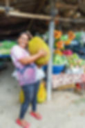 Indonesian woman carrying a jackfruit from a market stall in Bali, Indonesia