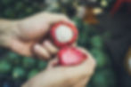 Market vendor holds open a fresh mangosteen to show a customer in Southeast Asia