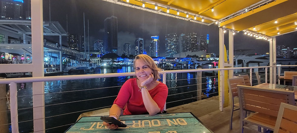 A tourist orders food at Landshark's patio in Bayside Market Place in Miami, featuring the beautiful Miami skyline in the background