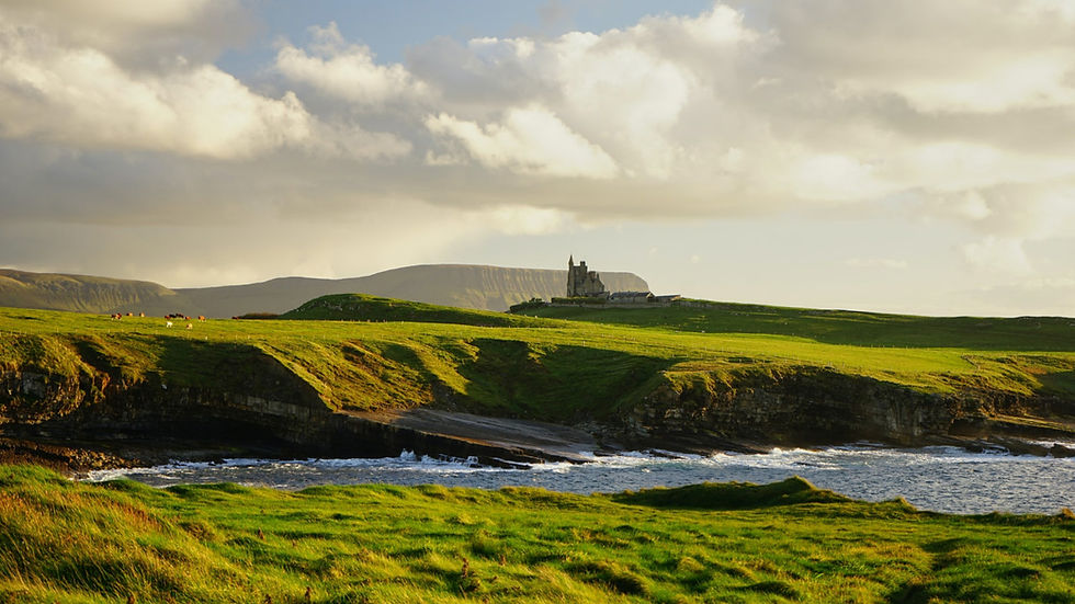 Green grass of the Emerald Isle. Blue skies over green and a Castle by the sea in Donegal, Ireland