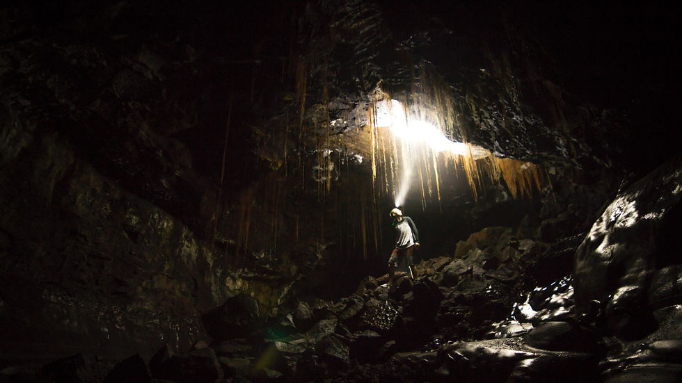 A man with a headtorch exploring the incredible caves at Kaumana Caves State Park near Hilo, Hawaii
