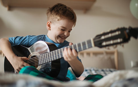 happy-boy-playing-on-the-guitar-in-his-room-2023-04-05-18-06-56-utc.jpeg