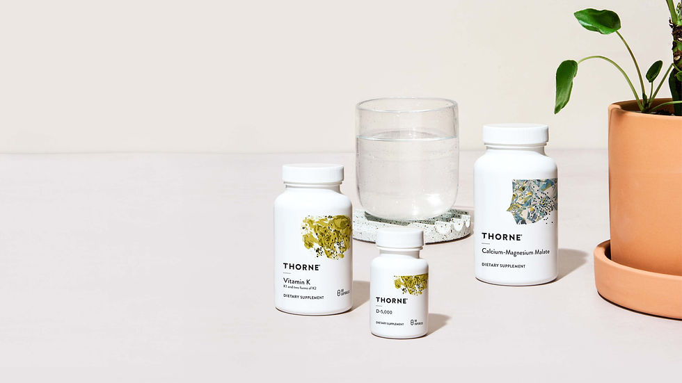 Close-up view of vitamin D and K supplement bottles with natural ingredients in the background