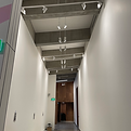 Modified track lighting installed in an art gallery to provide flexible illumination for rotating art exhibits.