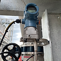 Installed industrial pressure sensor connected to a control system PLC for real-time monitoring.