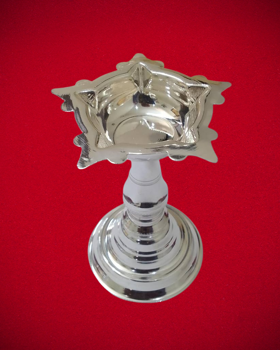 A close-up view of a handcrafted pure silver Vinayagar statue, showing finely detailed carving and a polished shine, perfect