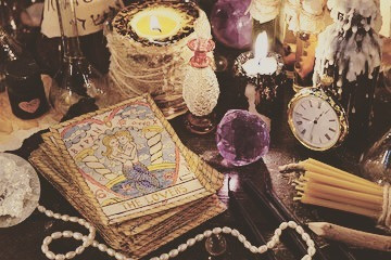 tarot cards, candles, watch, pearls, crystals