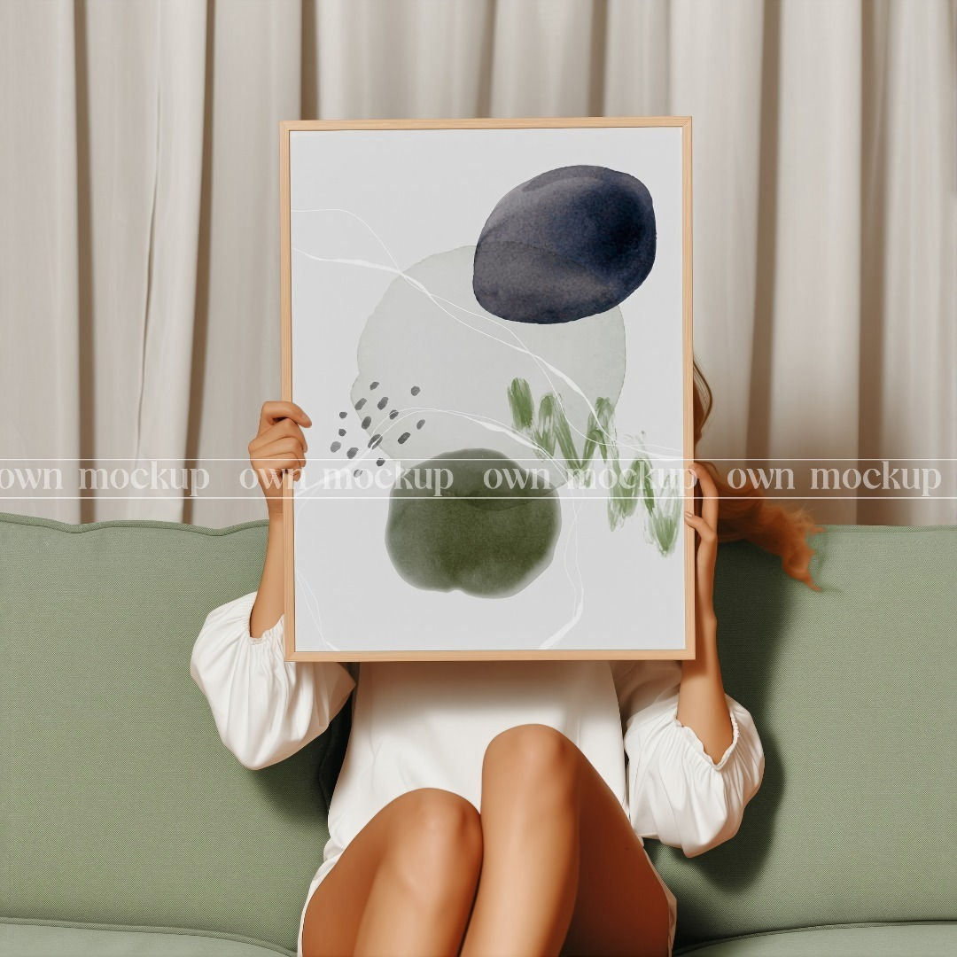 Girl seating on a sofa holding a frame mockup