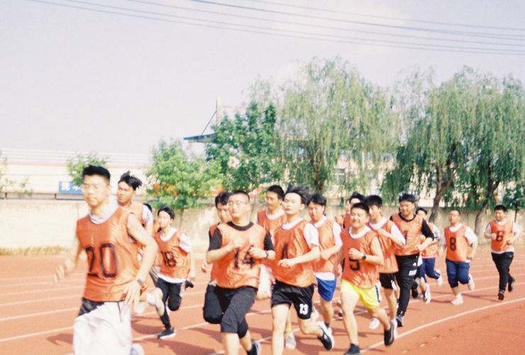 Une image dynamique montrant un groupe de personnes souriantes et énergiques pendant un cours de fitness en salle.