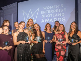 Women smiling and holding awards