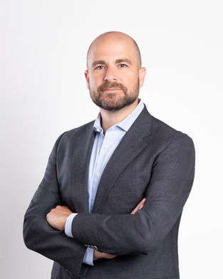 Man looking into camera in front of a white backdrop