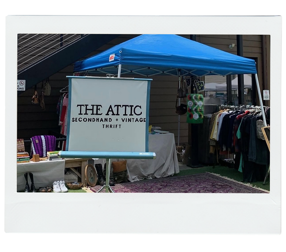 The Attic, a vintage thrift store small business that sells unique vintage clothes, vintage home decor and more, set up at a market.
