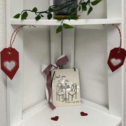 Cozy decor details including paper hearts and an illustrated tile with the words Just You and Me and a Cup of Tea at ConnectedLiving in Cham