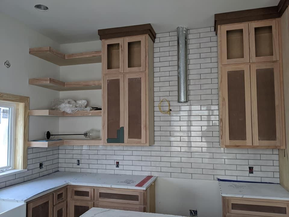 Residential tile installation of white subway backsplash.
