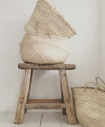Handwoven natural bag displayed on rustic wooden stool highlighting artisanal home design and natural materials.