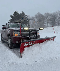 Skyline truck with a snowplow plowing snow from a road.