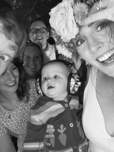 Stylish mum, baby and friends posing for photo booth at wedding.