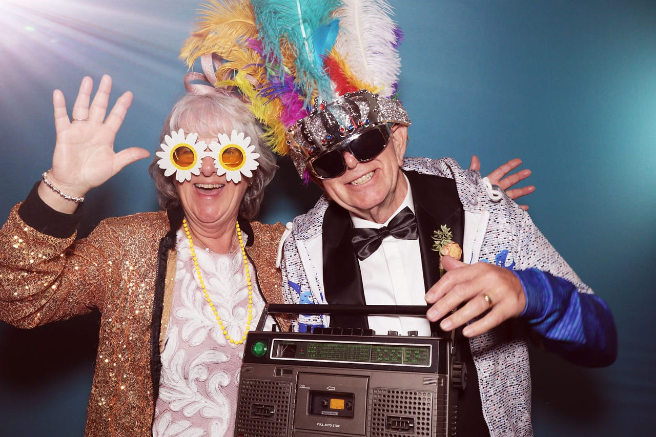 Parents of the groom smiling with fun props