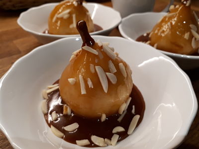 Poire pochée  dasn un sirop maison badiane, cannelle, vanille, sauce caramel maison, amandes