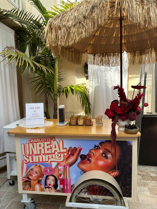 Mobile dessert cart rental with colorful signage and tropical decor for a brand activation for Charlotte's Unreal Summer