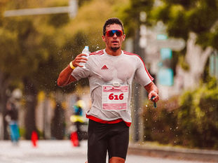 Atleta correndo em maratona bebendo água